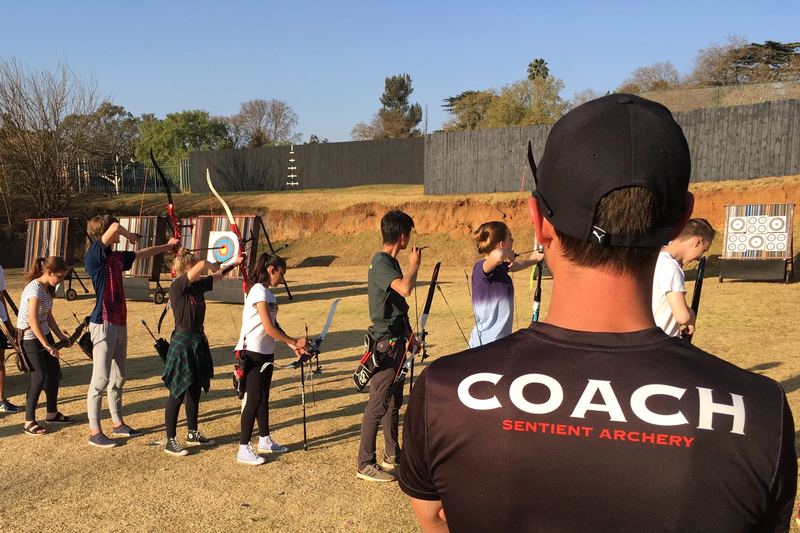 A coach watching a beginner class on the shooting line