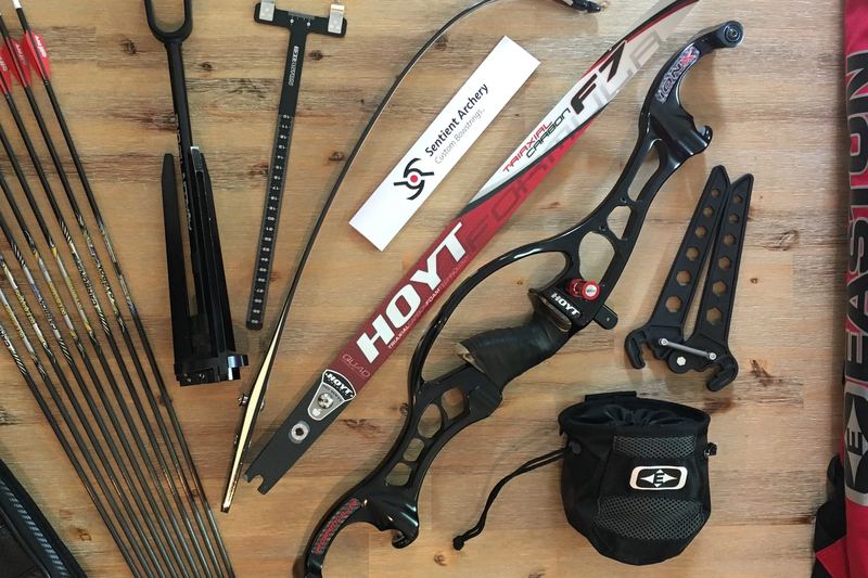 A recurve bow, arrows and accessories laid out